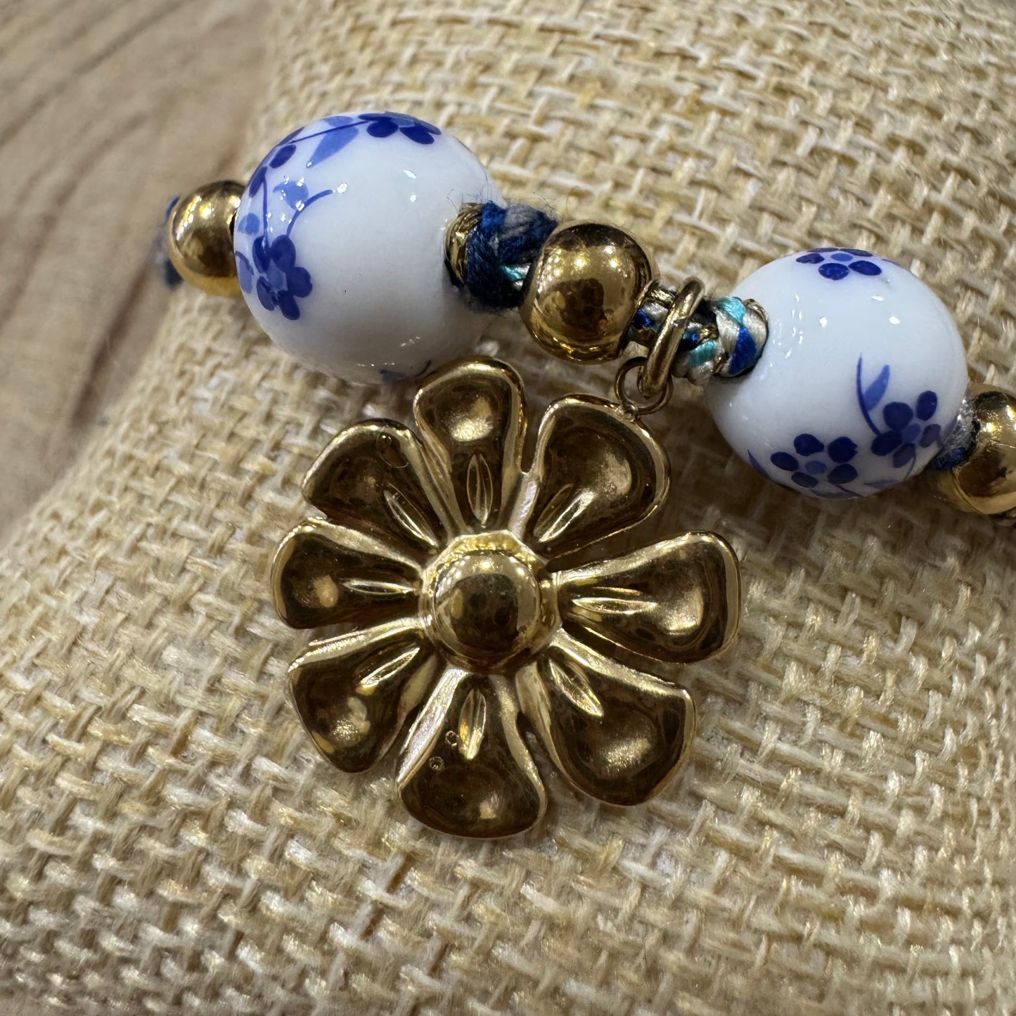 Pulseira Corda com Bolas de Flores Azuis e Brancas e Flor de Inox Dourado